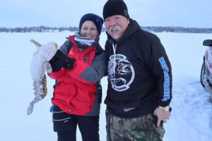 Guests enjoying ice fishing on frozen lake in Yellowknife with North Star Adventures