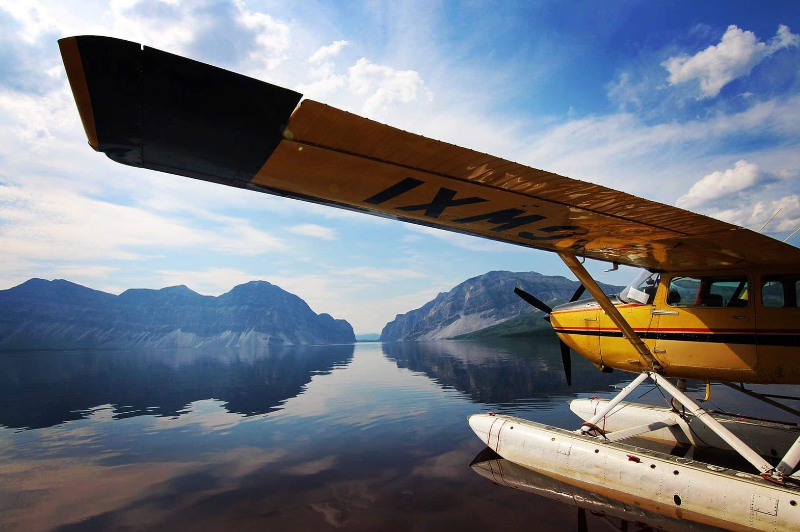 yellow float plane waits along shore to head out to arctic