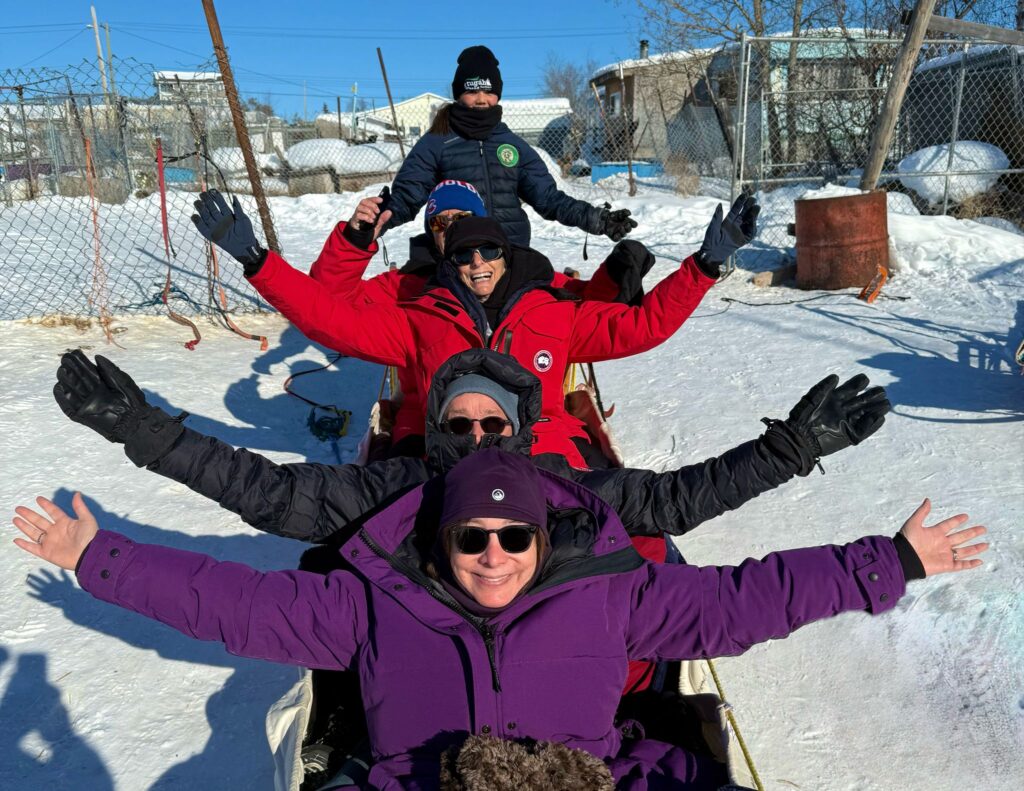 Group of people in sled with guide ready to go on ride