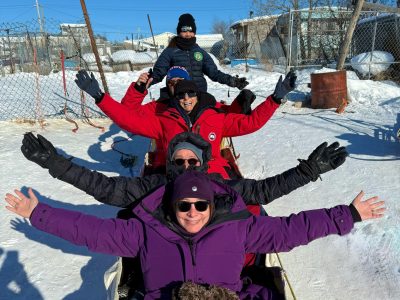 Group of people in sled with guide ready to go on ride