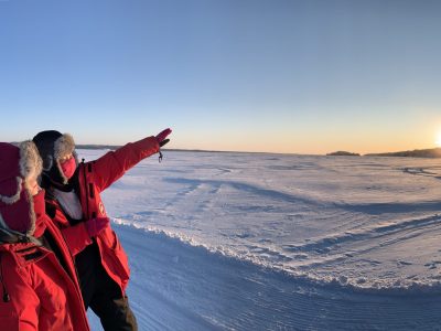 2 people wearing red jackets point to sunshine